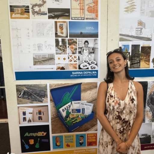 Graduating architecture student standing beside her senior thesis board at a student work exhibition