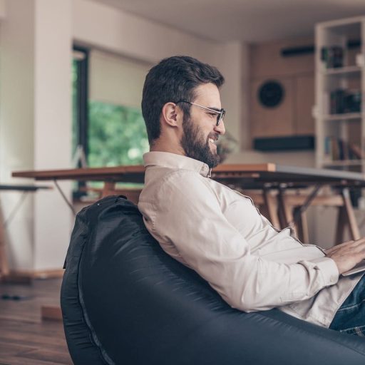 smiling-man-with-laptop-indoors-B3U679G